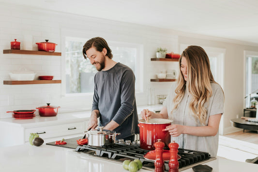 A happy couple cooking together in a modern kitchen. Enjoy a fully equipped space with high-quality appliances that fit your lifestyle.