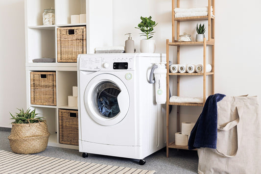A modern laundry setup in a Canadian home featuring a compact front-load washing machine with eco-friendly filtration, surrounded by minimalist shelving and organized essentials.